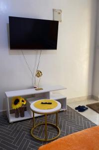 a living room with a table and a tv at Tulivu Homes in Meru