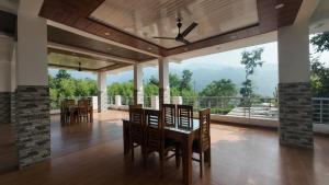 a dining room with a table and chairs and a balcony at Dreamland Resort in Nainital