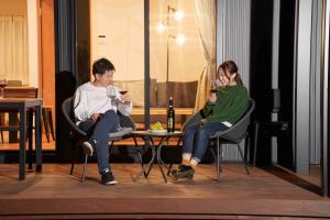 a man and woman sitting at a table with wine glasses at Villas Fuji Terrace ヴィラス富士テラス in Fujikawaguchiko +30 photos