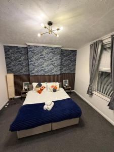 a bedroom with a bed with a blue accent wall at A&A Luxury Stay Rosedale - 4 Bed Residence in Sunderland