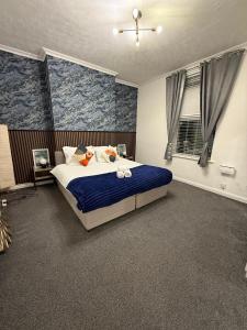 a bedroom with a large bed with blue walls at A&A Luxury Stay Rosedale - 4 Bed Residence in Sunderland