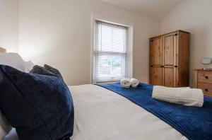 a bedroom with a bed with towels on it at Ribby Stays - 2 bed Cottage Pet Friendly in Wrea Green