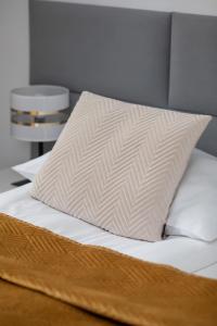 ein Bett mit einem weißen Kissen darauf in der Unterkunft Perłowa Przystań Unique Apartment with Air Conditioning and Parking Space in Kołobrzeg by Noclegi Renters in Radzikowo