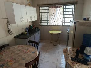 a kitchen with a table and a refrigerator at Sitio Pé da Serra São Pedro in São Pedro