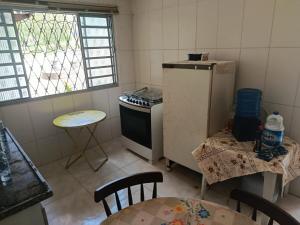 a kitchen with a refrigerator and a table and chairs at Sitio Pé da Serra São Pedro in São Pedro +20 photos