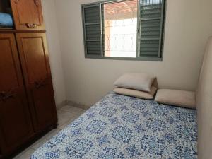 a bedroom with a bed with a blue and white blanket at Sitio Pé da Serra São Pedro in São Pedro