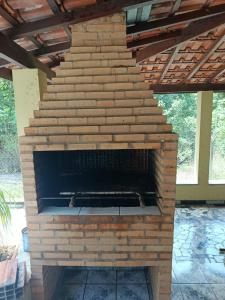 an outdoor brick fireplace with a roof at Sitio Pé da Serra São Pedro in São Pedro
