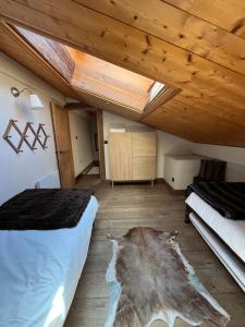 a attic bedroom with two beds and a skylight at Appartement du Petit Bois in Megève