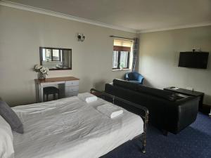 a hotel room with a bed and a couch at The Swan Inn in Hilborough
