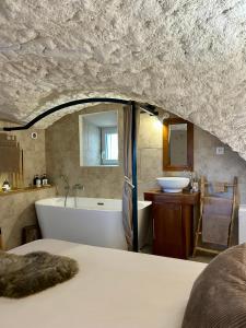 a bathroom with a bed and a tub and a sink at Le Cocon Secret in Saint-Cyr
