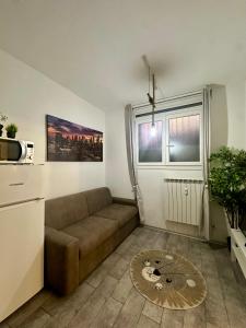een woonkamer met een bank en een keuken bij Affori- Apartment Milan in Milaan