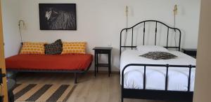 a bedroom with a bed and a chair in it at Maison d'hôtes MOURENIA Aroue in Aroue