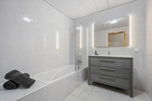 a white bathroom with a tub and a sink at Sunny Ponta "Nomads' village" in Ponta do Sol +41 photos