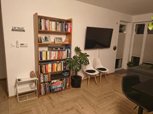 ワンツトにあるApartament Rutkiewiczの書棚付きのリビングルーム