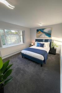 a bedroom with a king sized bed in a room with windows at Luxury Airport Home with Driveway and Garden- Sleeps 7 in Ashley +17 photos