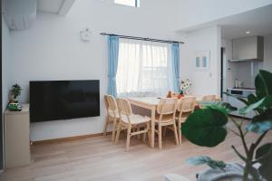 a living room with a table and chairs and a television at Mulan Stay 松尾大社 in Kyoto