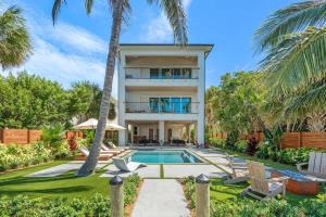 a house with a swimming pool and palm trees at One Palm in South Cocoa Beach