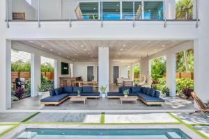 an outdoor living room with blue couches and a pool at One Palm in South Cocoa Beach