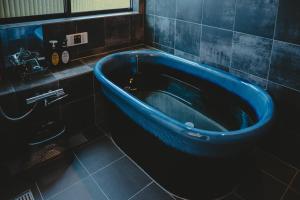 a blue tub in a bathroom with a sink at Mulan Stay 松尾大社 in Kyoto +81 photos