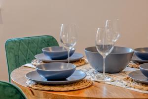 a wooden table with bowls and wine glasses on it at The Loft at 2 Bath Street in Bath