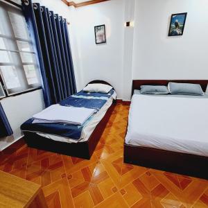 twee bedden in een kamer met houten vloeren bij Vang Vieng SCK Hotel in Vang Vieng