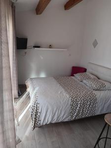 a bedroom with a bed with a white comforter at Studio sympa meublé avec parking privé et piscine in Manosque