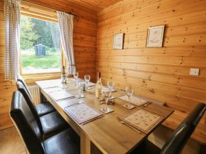 a wooden dining room with a table with wine glasses at Dan Y Coed in Discoed