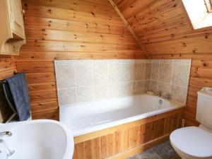 a bathroom with a tub and a toilet and a sink at Dan Y Coed in Discoed +24 photos