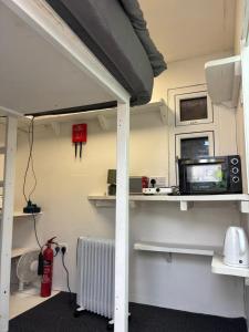 ピーターバラにあるThe Cosy Garden Hideoutのベッド、電子レンジ、ヒーターのある部屋