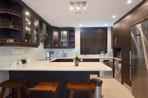 una cucina con lavello e frigorifero di Elegant Contemporary Apartment at Eden on the Bay a Big Bay Altre 25 foto
