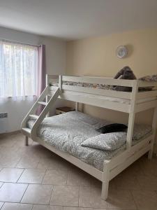 ein weißes Etagenbett in einem Zimmer mit Fenster in der Unterkunft Cosy Cottage on the Lake in Écuras + 21 Fotos