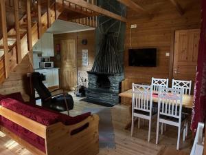 a living room with a table and a fireplace at Immelmökit in Levi