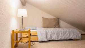 a bedroom with a bed and a table with a lamp at Le Refuge du Forchat in Bellevaux