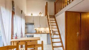 a kitchen with a staircase leading up to a loft at Le Refuge du Forchat in Bellevaux