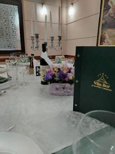 a table with wine glasses and flowers on it at Guest house Vila Bor in Novi Sad