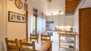a kitchen with a wooden table and a table and chairs at Le Refuge du Forchat in Bellevaux +4 photos