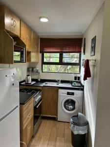 eine Küche mit einer Waschmaschine und einem Geschirrspüler in der Unterkunft Khaled Estate Cottages in Hillcrest