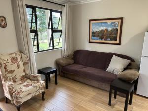ein Wohnzimmer mit einer Couch und einem Sessel in der Unterkunft Khaled Estate Cottages in Hillcrest