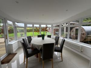 DocklowにあるRed Gables at Pudleston Courtのテーブルと椅子と窓のあるダイニングルーム