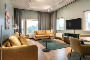 a living room with a couch and a tv at Scandic Eden Nokia in Nokia