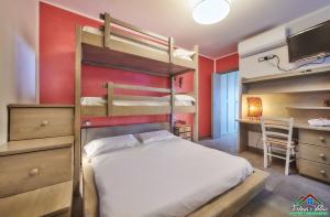 a bedroom with two bunk beds and a desk at Sunset Apartment with Air Conditioning and Lake View in Perledo