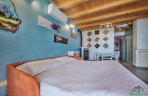 a large bed in a room with a blue wall at Sunset Apartment with Air Conditioning and Lake View in Perledo