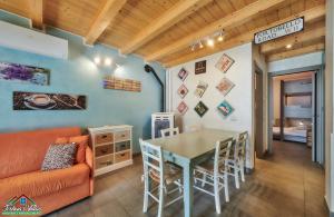 a living room with a couch and a table and chairs at Sunset Apartment with Air Conditioning and Lake View in Perledo