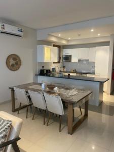 a large kitchen with a wooden table and chairs at Golden Dawn Villa in As Sīfah