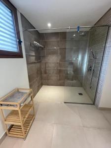 a bathroom with a shower with a glass door at Golden Dawn Villa in As Sīfah +10 photos