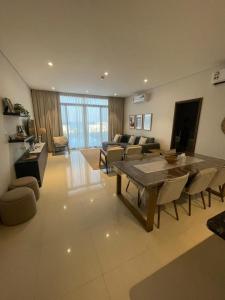 a living room with a table and a couch at Golden Dawn Villa in As Sīfah
