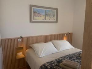 ein Bett in einem Schlafzimmer mit einem Bild an der Wand in der Unterkunft Suite hôtelière face à la mer in Santec