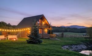 a cabin in the woods with lights on it at Chatka nad Stawami 