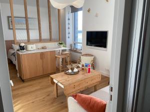 ein kleines Wohnzimmer mit einem Tisch und einer Küche in der Unterkunft Suite hôtelière face à la mer in Santec