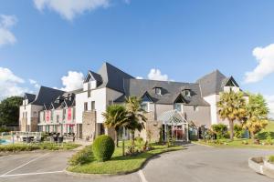 a large white building with a black roof at Les Ormes Domaine et Resort in Epiniac